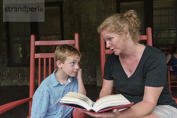 Kaukasische Mutter und Sohn lesen auf der Terrasse