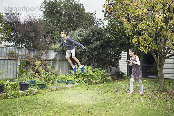 Gemischtrassige Kinder spielen mit Schwebespielzeug im Hinterhof
