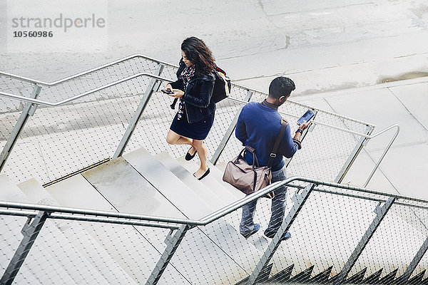 Menschen  die auf den Stufen der Stadt Handys benutzen