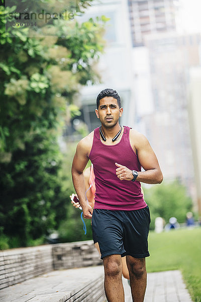 Indischer Mann joggt in der Stadt