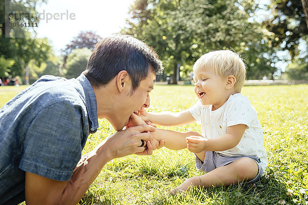 Vater und Sohn spielen im Gras im Park