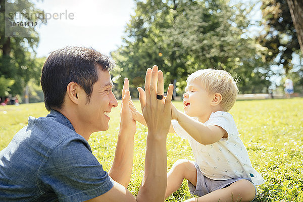 Vater und Sohn spielen im Gras im Park