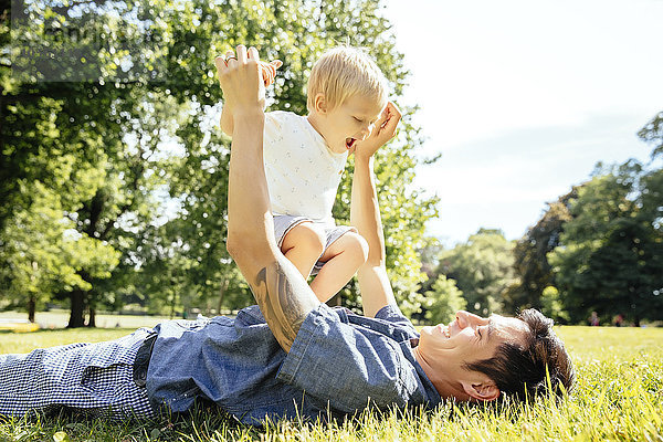 Vater und Sohn spielen im Gras im Park