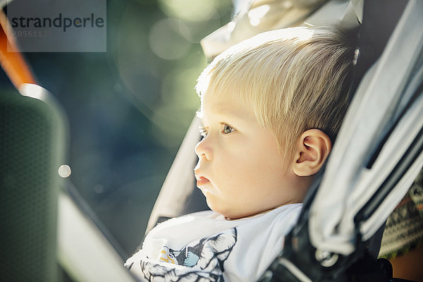 Nahaufnahme eines gemischtrassigen Jungen  der im Kinderwagen sitzt