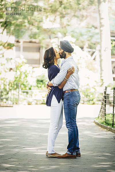 Indisches Paar küsst sich im Stadtpark