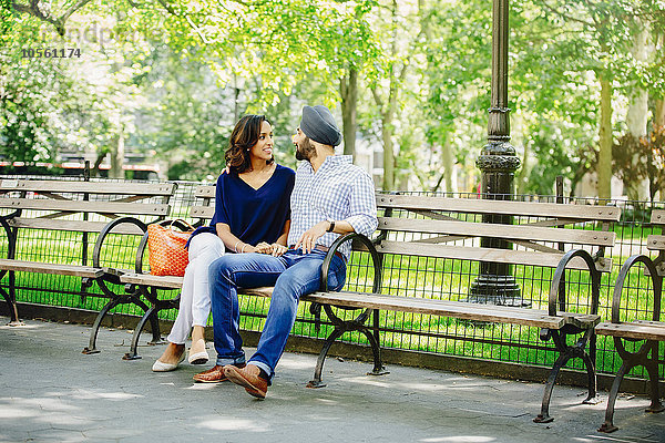 Indisches Paar sitzt auf einer Bank im Stadtpark