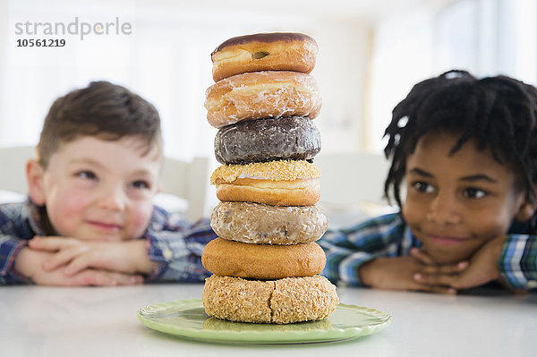 Jungen bewundern einen Stapel Donuts auf der Theke