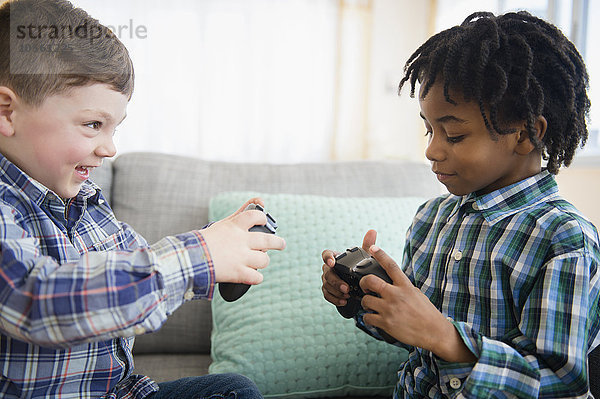 Jungen spielen Videospiele auf dem Sofa