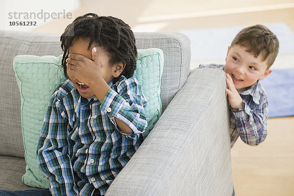 Nahaufnahme von Jungen  die im Wohnzimmer Verstecken spielen