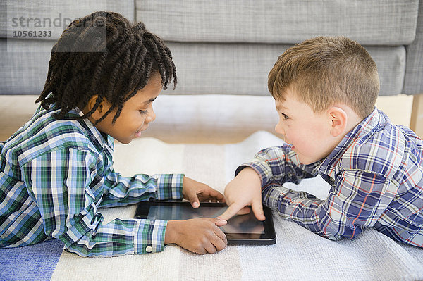 Jungen spielen mit digitalem Tablet auf dem Sofa