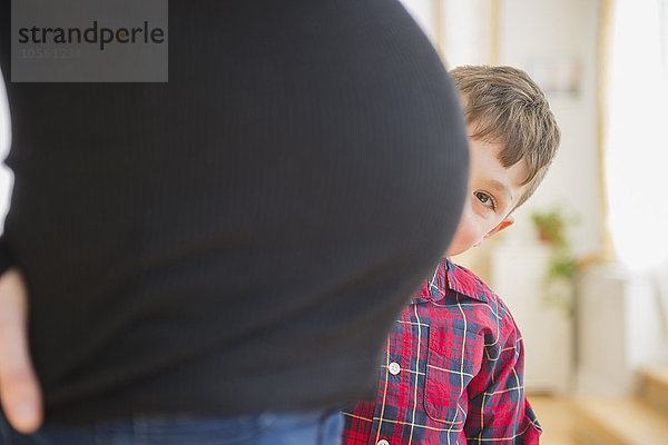 Junge bewundert Bauch der schwangeren Mutter