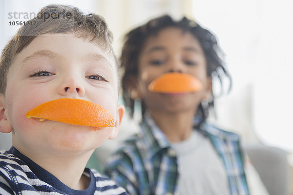 Jungen beißen in Orangenscheiben