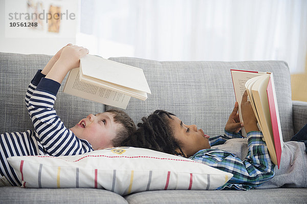 Jungen lesen auf dem Wohnzimmersofa
