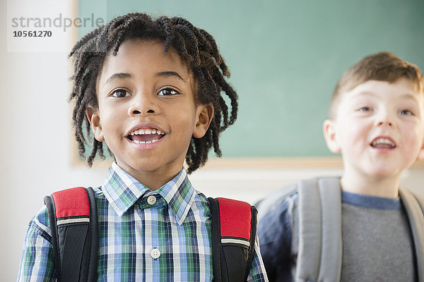 Schüler tragen Rucksäcke im Klassenzimmer