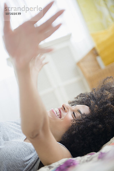 Gemischtrassige Frau auf dem Bett liegend