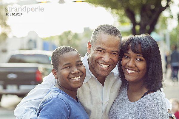 Afroamerikanischer Vater und Kinder umarmen sich in der Stadt