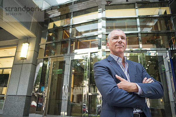 Kaukasischer Geschäftsmann steht vor einem Bürogebäude