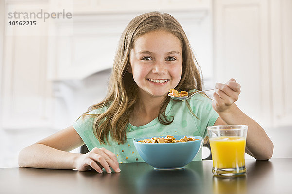 Kaukasisches Mädchen isst Müsli am Tisch