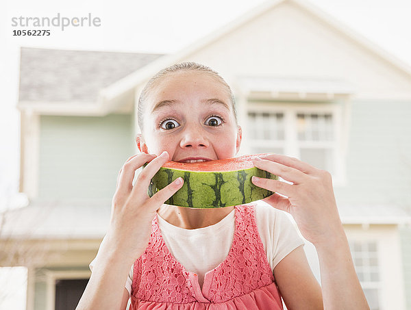 Kaukasisches Mädchen isst Wassermelone im Freien