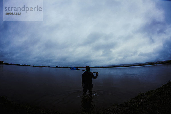 Kaukasischer Mann steht in einem stillen  abgelegenen See