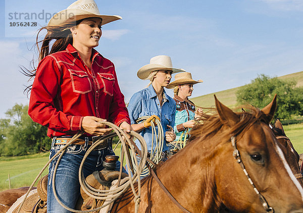 Cowgirls reiten Pferde auf einer Ranch