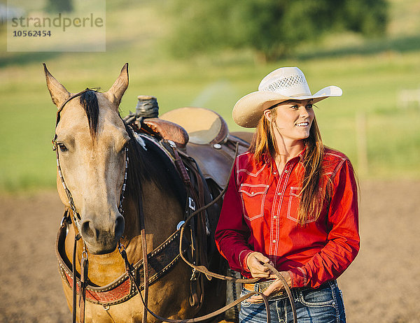 Kaukasisches Cowgirl mit Pferd auf einer Ranch