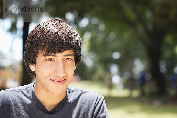 Hispanischer Teenager lächelt im Park