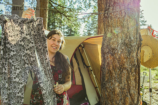 Kaukasische Frau hängt Wäsche auf dem Campingplatz auf