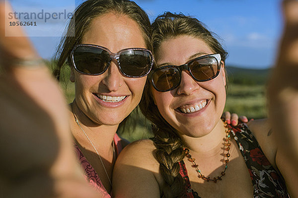 Kaukasische Frauen mit Sonnenbrille machen ein Selfie