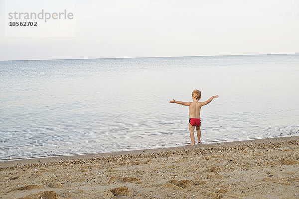 Kaukasischer Junge spielt am Strand