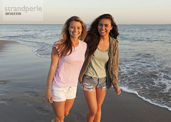 Frauen gehen am Strand spazieren