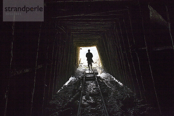 Mari Mann geht auf Schienen im Bergwerk