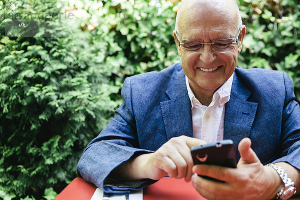 Hispanischer Geschäftsmann  der ein Mobiltelefon benutzt