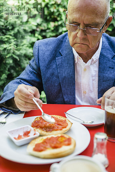 Hispanischer Geschäftsmann beim Frühstück im Freien