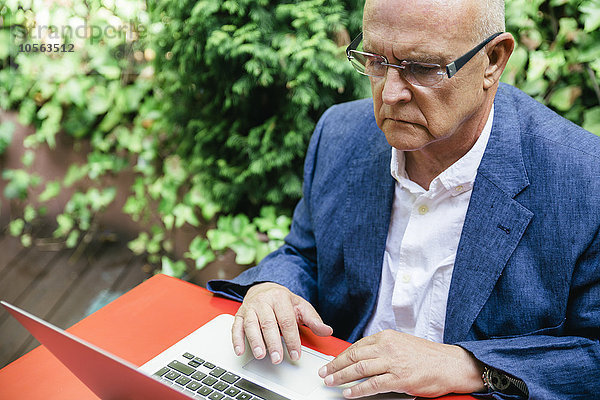 Hispanischer Geschäftsmann benutzt Laptop im Freien