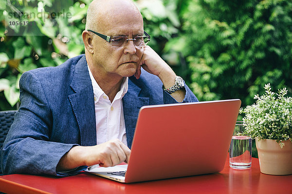 Hispanischer Geschäftsmann benutzt Laptop im Freien