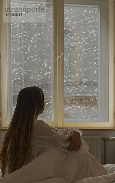 Kaukasische Frau schaut aus dem Fenster