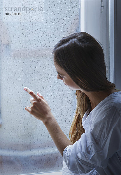 Kaukasische Frau schaut aus dem Fenster