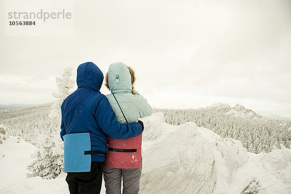 Kaukasische Wanderer auf einem Berggipfel bewundern die verschneite Landschaft