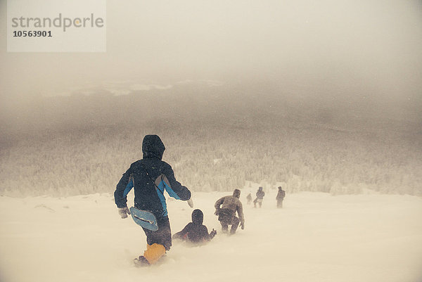 Kaukasische Wanderer  die auf einem verschneiten Hügel spazieren gehen