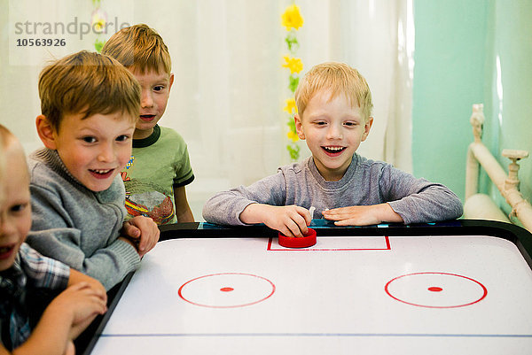 Kaukasische Jungen spielen Airhockey