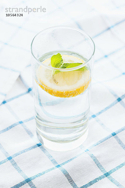 Nahaufnahme eines Glases mit Kräuterzitronenwasser