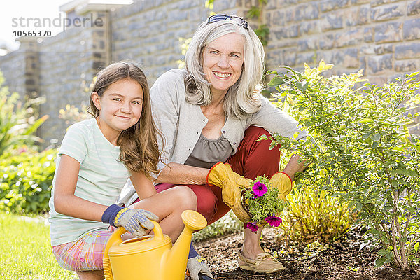 Kaukasische Großmutter und Enkelin bei der Gartenarbeit im Hinterhof