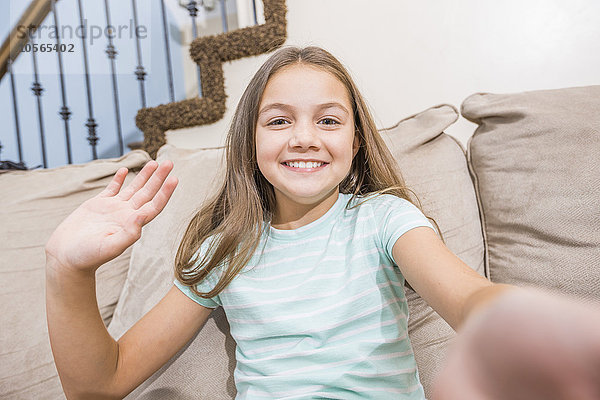 Kaukasisches Mädchen nimmt Selfie auf Sofa