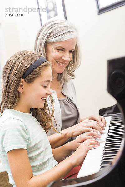 Kaukasische Frau gibt Schülern Klavierunterricht