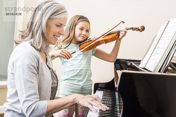 Kaukasische Großmutter und Enkelin musizieren zusammen