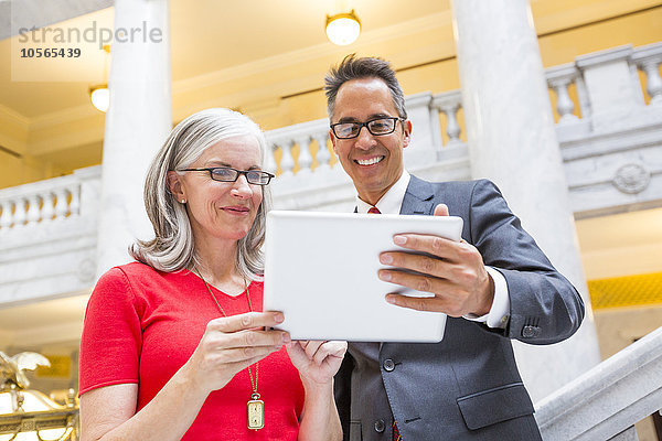 Geschäftsleute nutzen digitales Tablet im Gerichtssaal