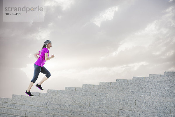 Kaukasische Frau joggt auf Stufen