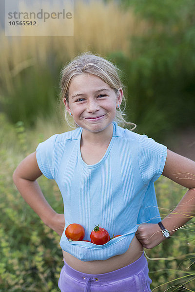 Kaukasisches Mädchen trägt Tomaten im Hemd