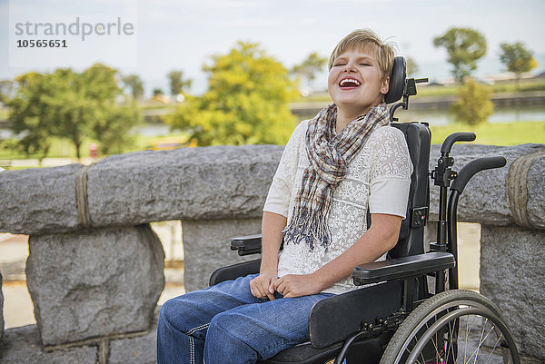 Querschnittsgelähmte Frau lacht im Rollstuhl